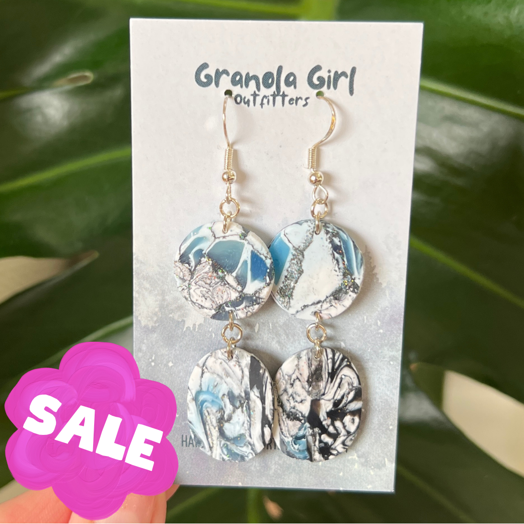 Earrings on a 'Granola Girl Outfitters' card with a 'SALE' tag, against a leafy green background.