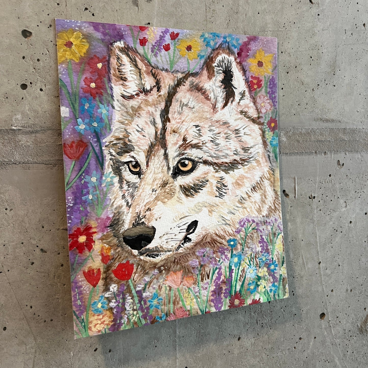 painting of a wolf surrounded by wildflowers