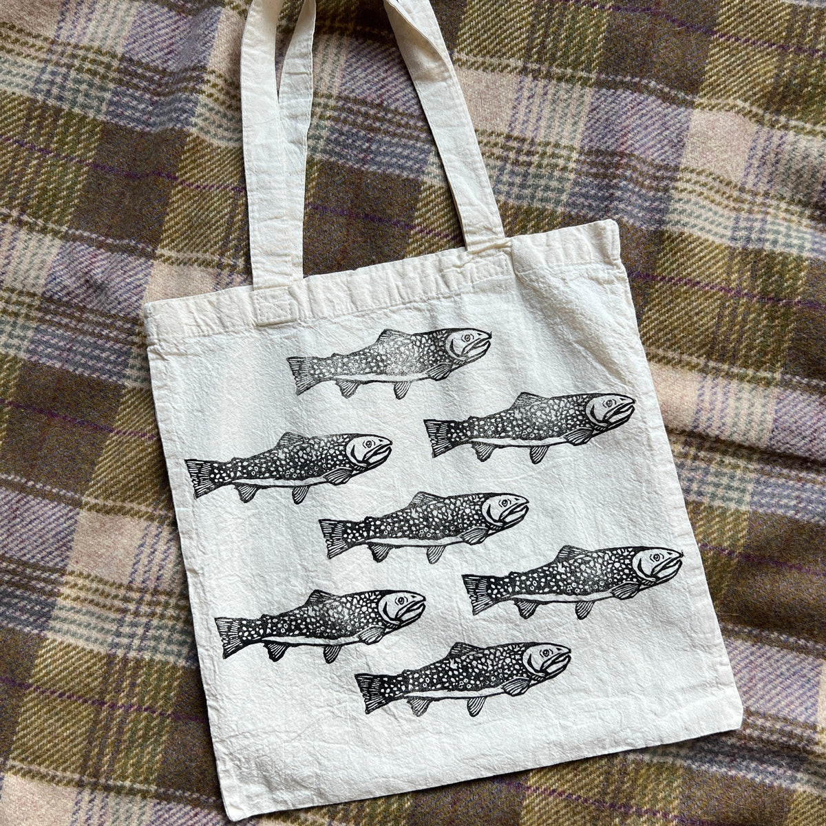 Tote bag with fish design on a plaid fabric background
