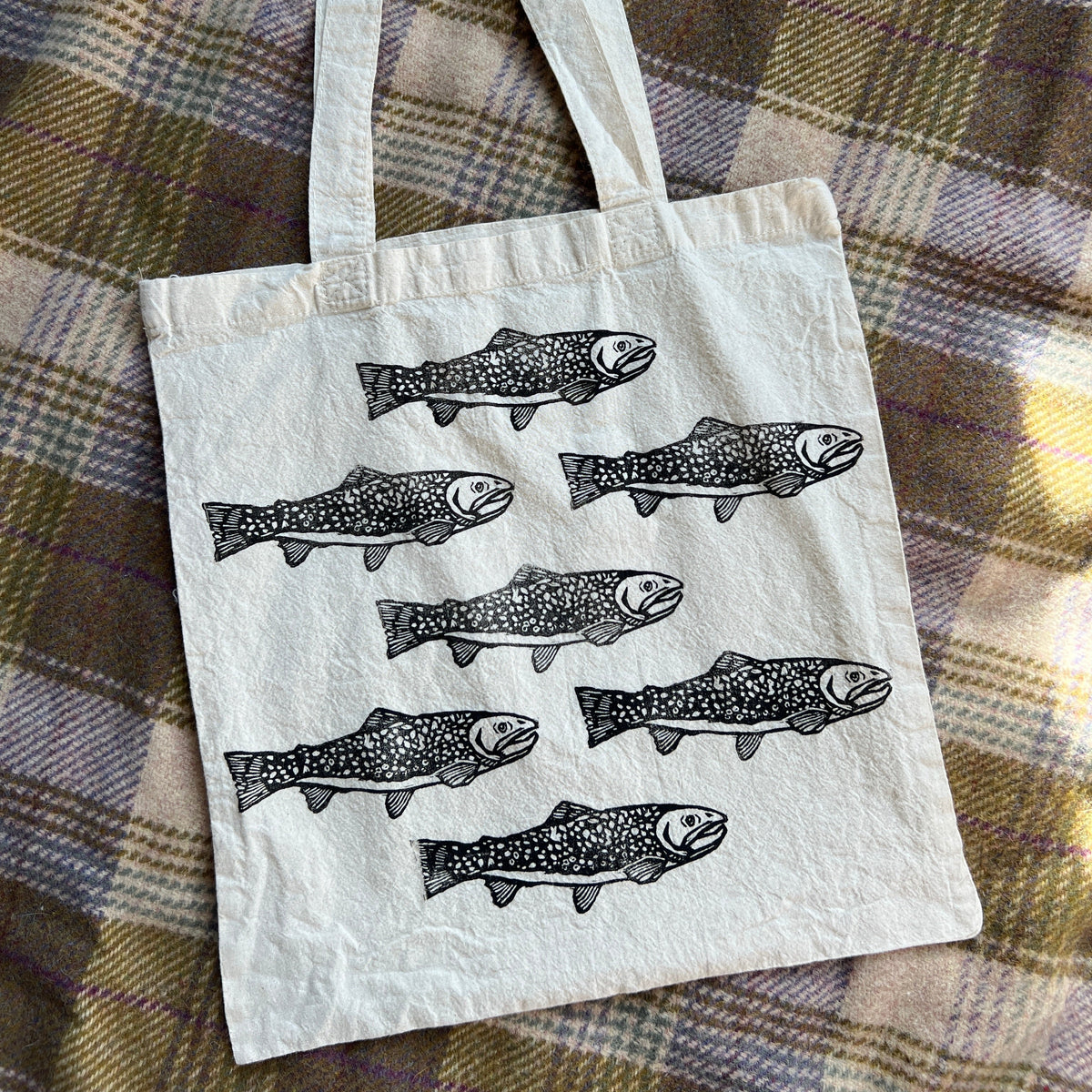 Tote bag with fish design on a plaid fabric background