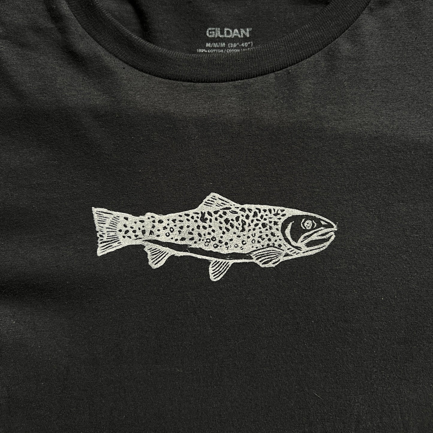 Black t-shirt with a white fish design on a checkered background