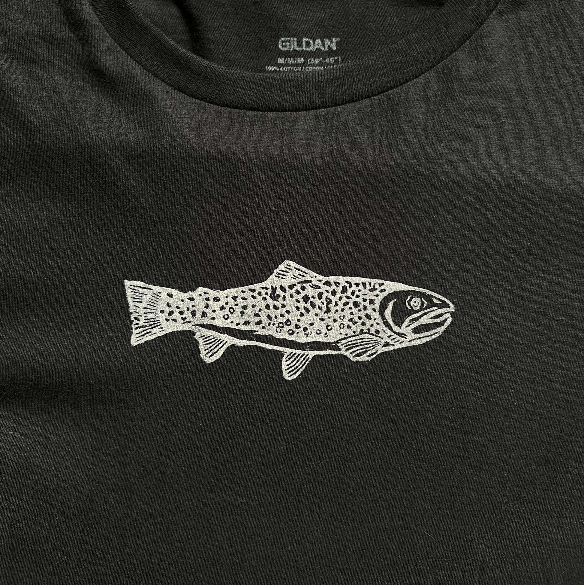 Black t-shirt with a white fish design on a checkered background