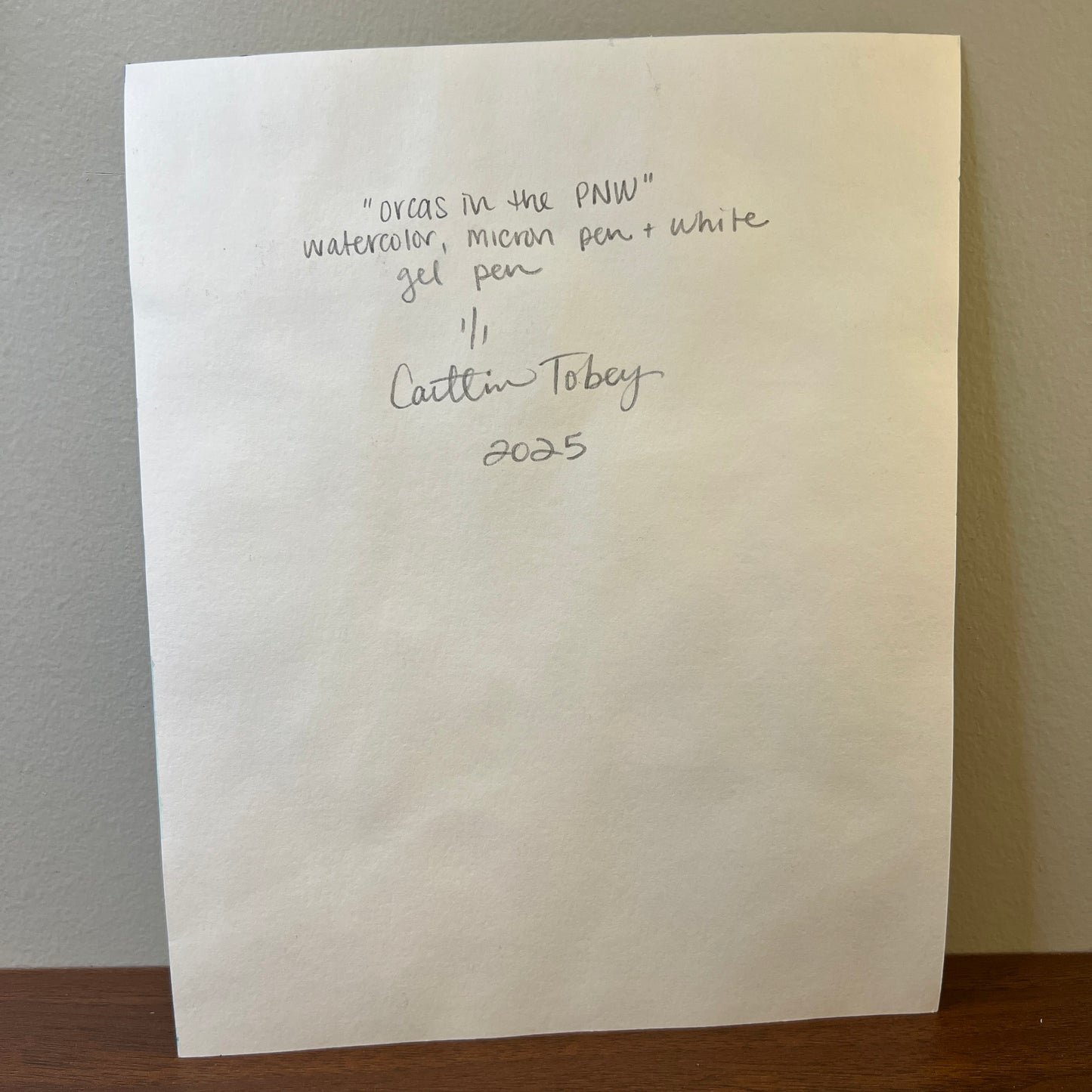 white paper with hand-written title of the art, medium, signature and date