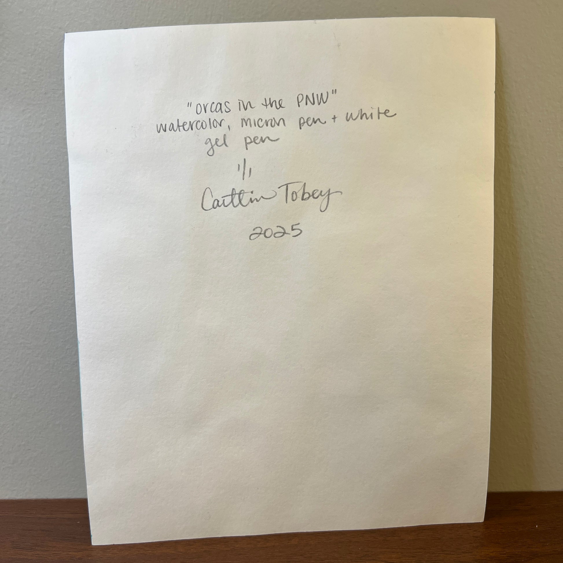 white paper with hand-written title of the art, medium, signature and date