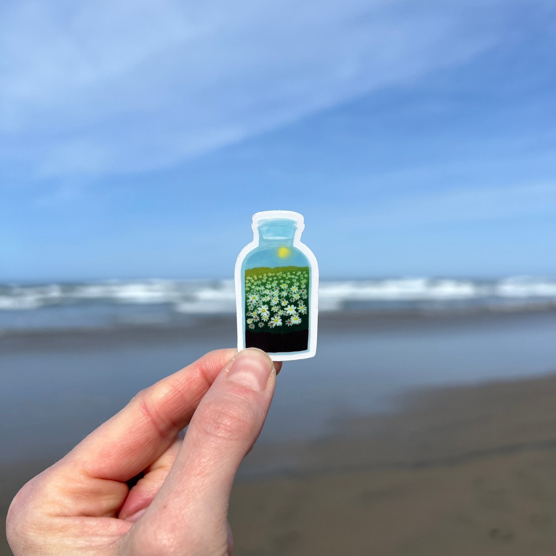 Hand holding a daisy terrarium sticker 