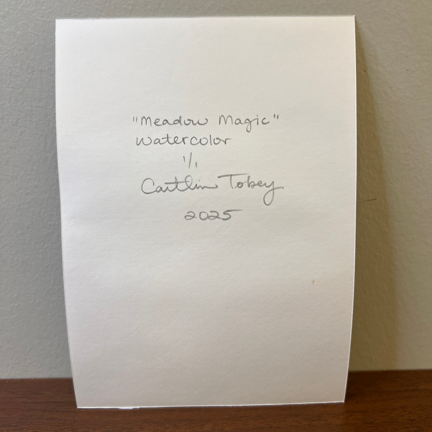 back of watercolor paper with handwritten artist signature and painting info