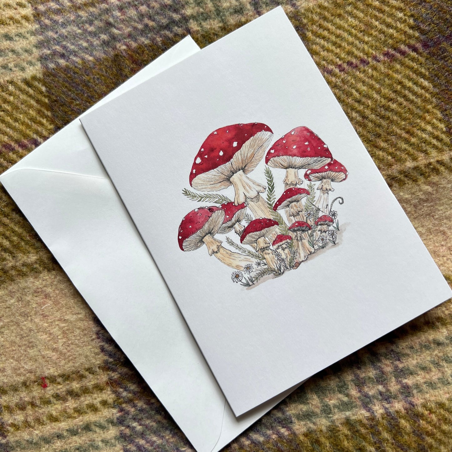 Greeting card with mushroom design on a plaid fabric background