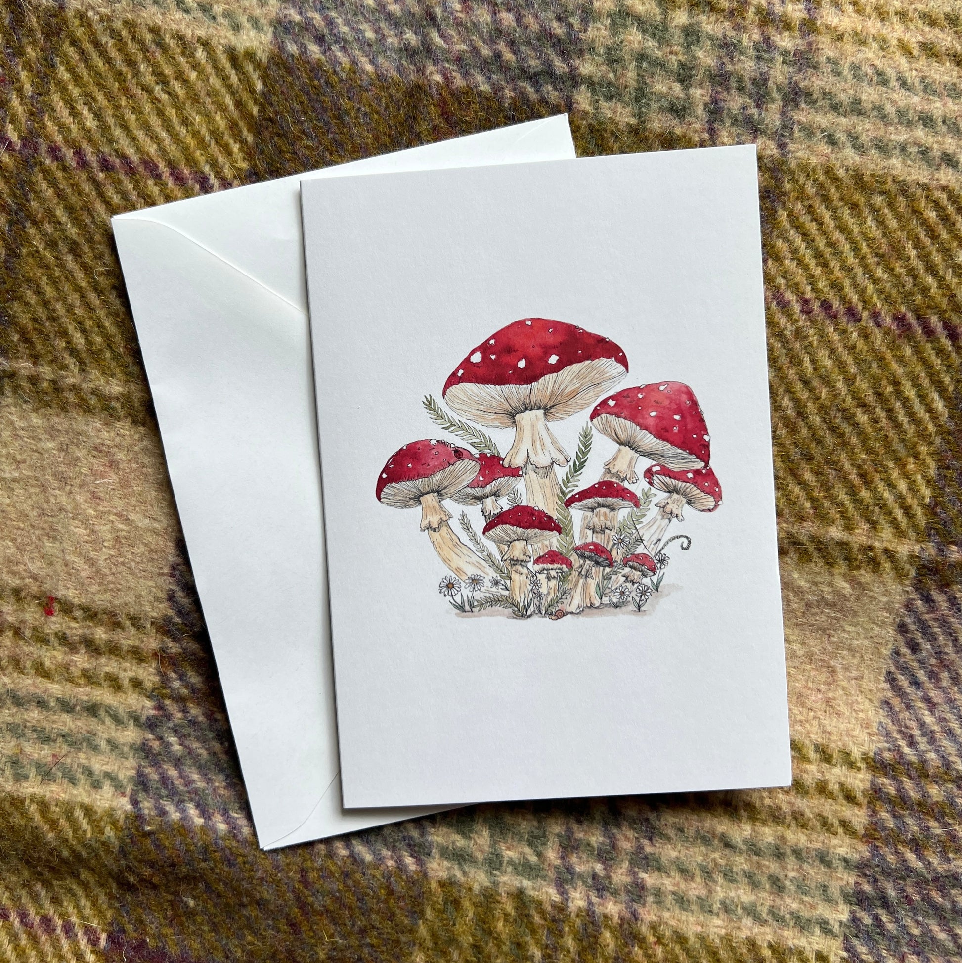 Greeting card with mushroom design on a plaid fabric background