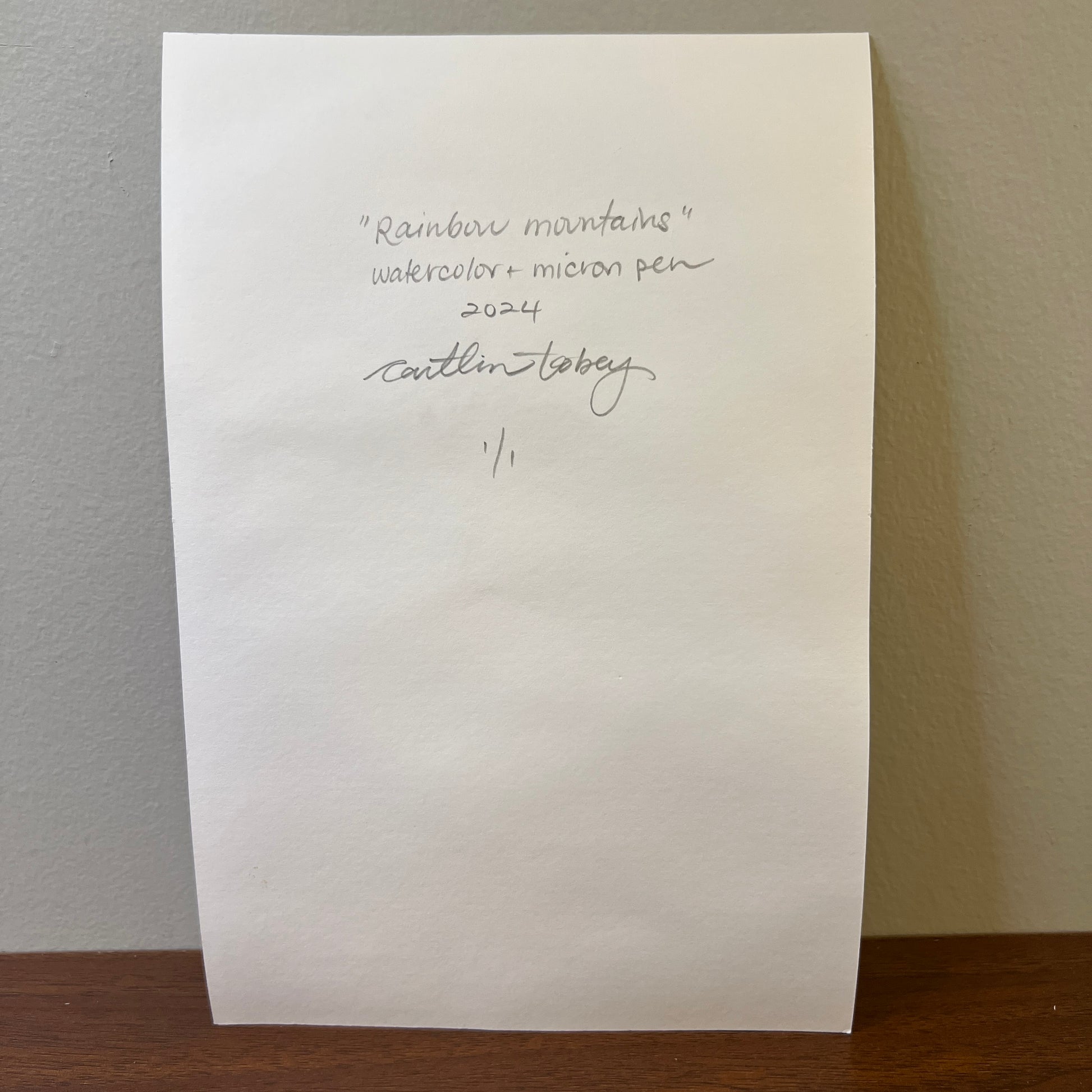 White paper with handwritten artist signature and painting details 