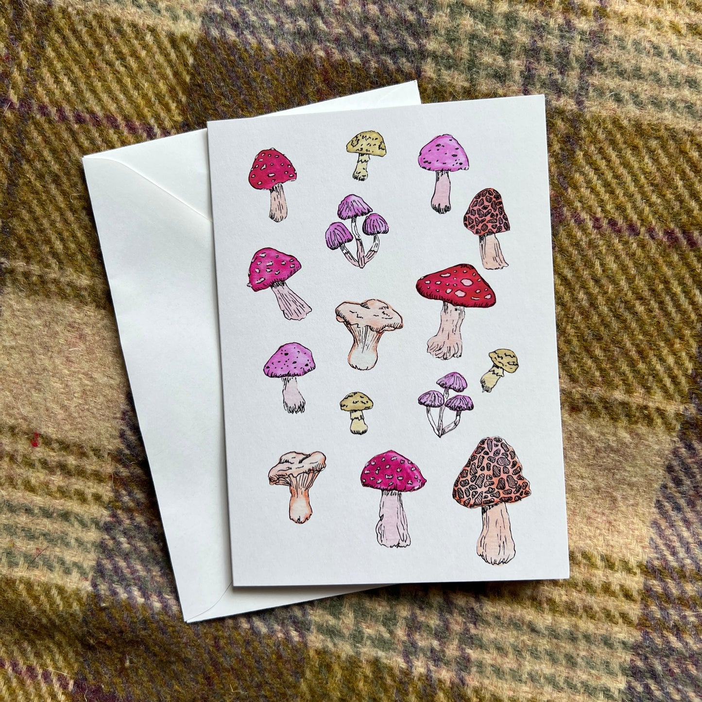Greeting card with mushroom illustrations on a plaid fabric background