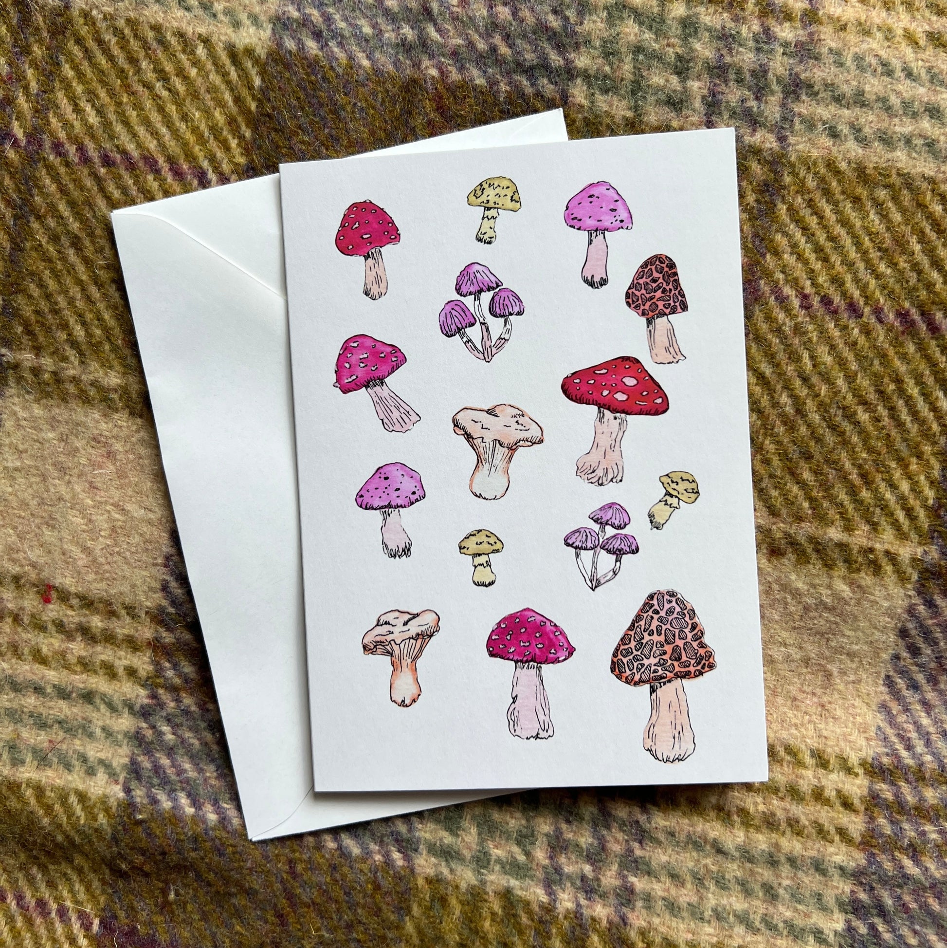 Greeting card with mushroom illustrations on a plaid fabric background